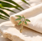 Gold palm tree brooch pin with green and clear crystals